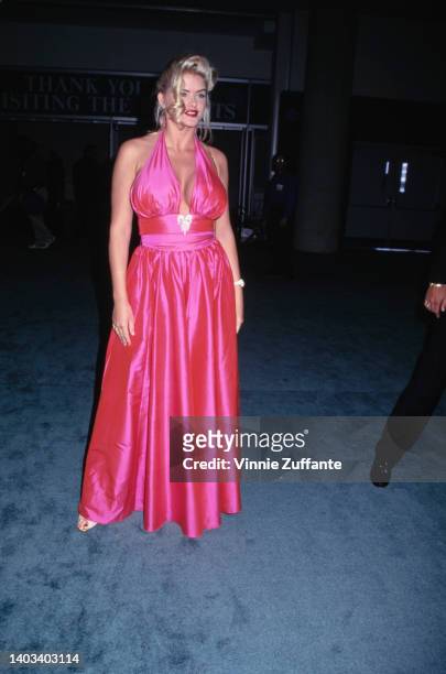 American glamour model and actress Anna Nicole Smith , wearing a pink halter neck evening gown, attends the Video Software Dealers Association...