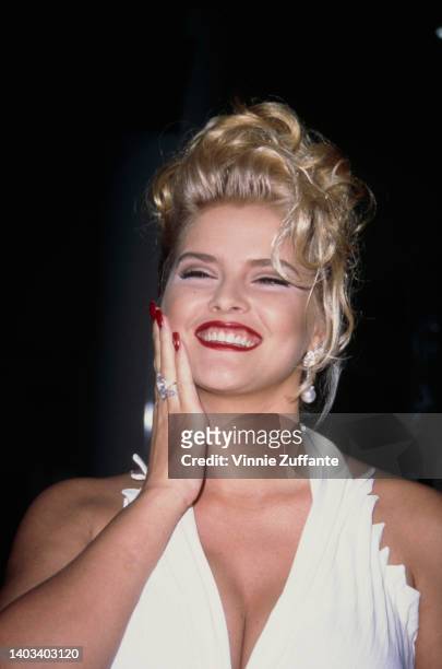 American glamour model and actress Anna Nicole Smith , wearing a white halter neck outfit, attends the opening of Planet Hollywood, at Caesar's...