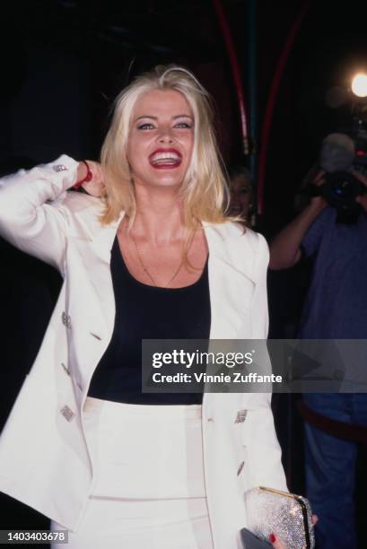 American glamour model and actress Anna Nicole Smith , wearing a white suit over a black scoop neck top, attends the Hollywood premiere of 'Volcano,'...