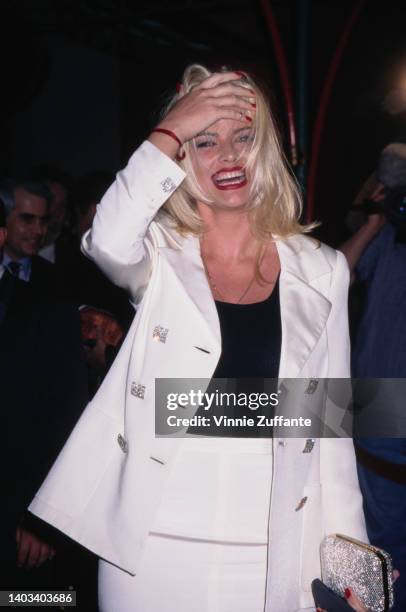 American glamour model and actress Anna Nicole Smith , wearing a white suit over a black scoop neck top, attends the Hollywood premiere of 'Volcano,'...