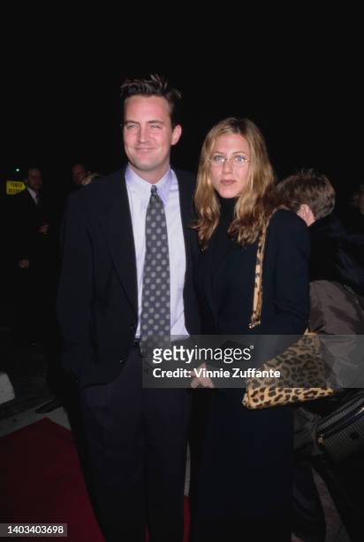 American-Canadian actor Matthew Perry and American actress Jennifer Aniston, with a leopard skin print bag, attend the Westwood premiere of 'Kissing...