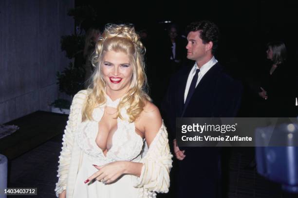American glamour model and actress Anna Nicole Smith , wearing a white dress with a lace keyhole bustier, attends the Westwood premiere of 'Ready to...