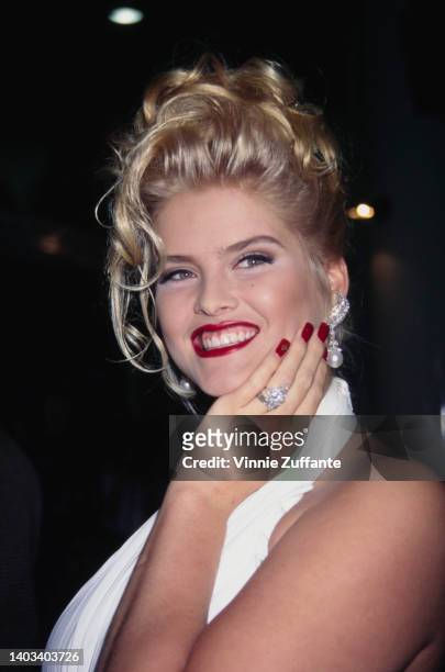 American glamour model and actress Anna Nicole Smith , wearing a white halter neck outfit, attends the opening of Planet Hollywood, at Caesar's...