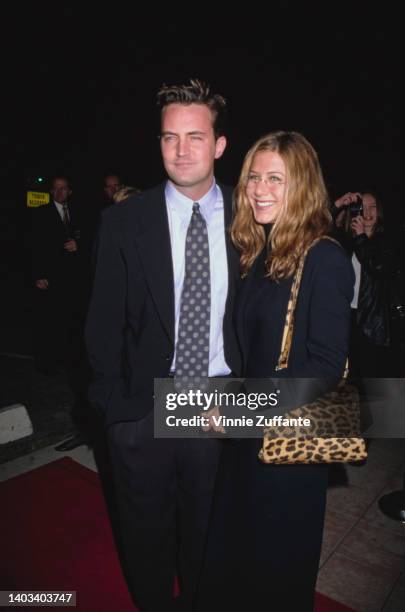 American-Canadian actor Matthew Perry and American actress Jennifer Aniston, with a leopard skin print bag, attend the Westwood premiere of 'Kissing...