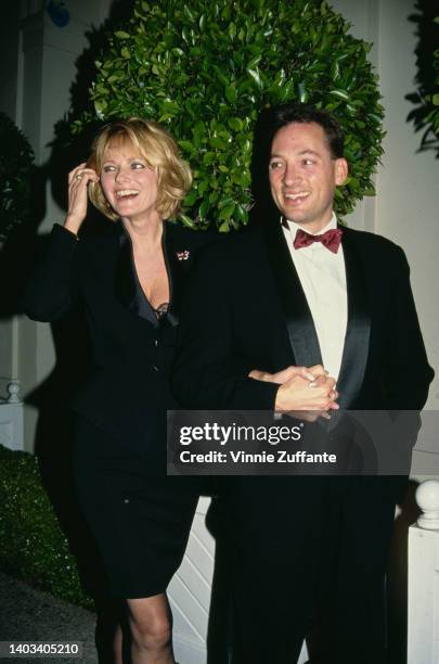America fashion model Cheryl Tiegs, wearing a black suit, and her husband, American actor Anthony Peck, wearing a tuxedo with a deep red bow tie,...