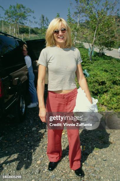 American actress Ellen Barkin wearing a grey t-shirt and red trousers attends the '95 Pediatric Aids Foundation Annual Picnic, held at a private...