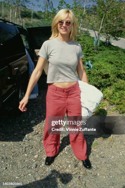 American actress Ellen Barkin wearing a grey t-shirt and red trousers attends the '95 Pediatric Aids Foundation Annual Picnic, held at a private...