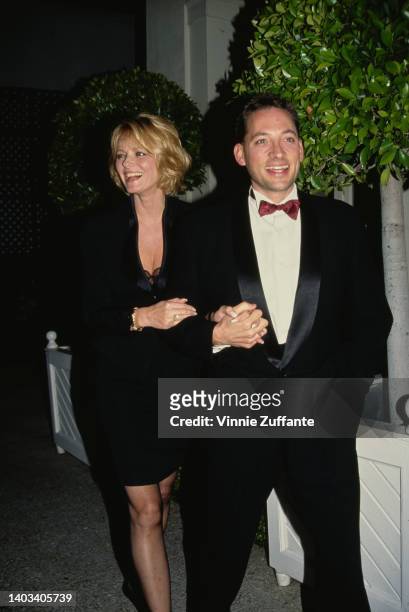 America fashion model Cheryl Tiegs, wearing a black suit, and her husband, American actor Anthony Peck, wearing a tuxedo with a deep red bow tie,...