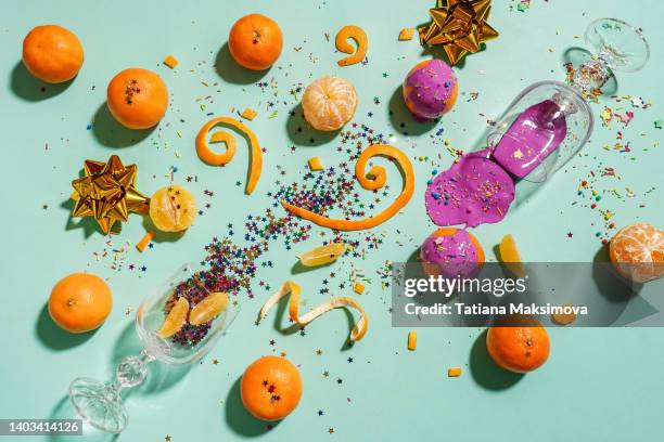 christmas bright composition with tangerines, confetti and wine glass with purple paint. flat lay, top view - top lay wine stock-fotos und bilder