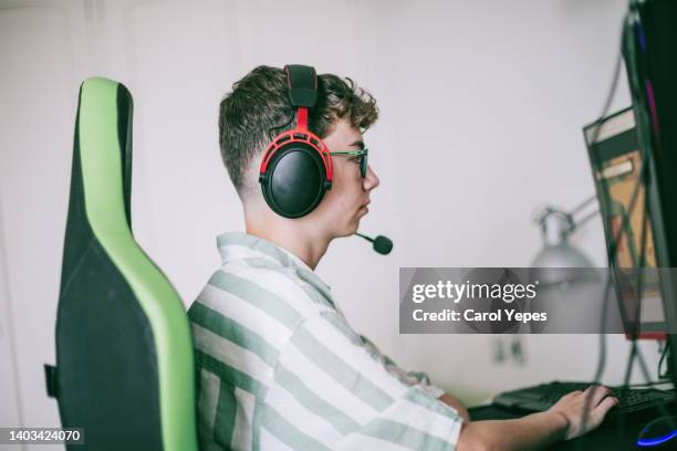 gamer teenager boy at home playing pc games - boy at television stockfoto's en -beelden