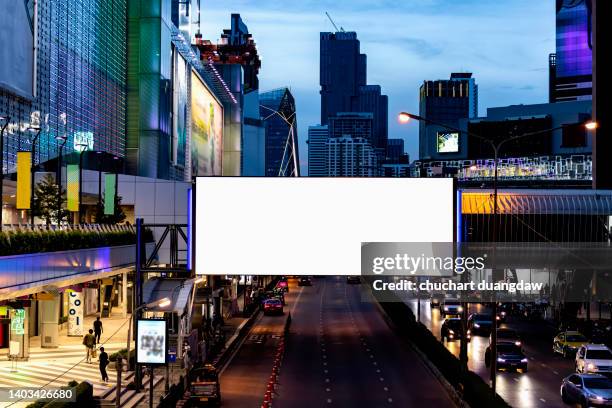 blank billboard advertising banner media display on city street at night - valla límite fotografías e imágenes de stock