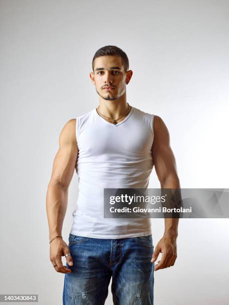 portrait of young man with white tank top - camiseta de tirantes fotografías e imágenes de stock
