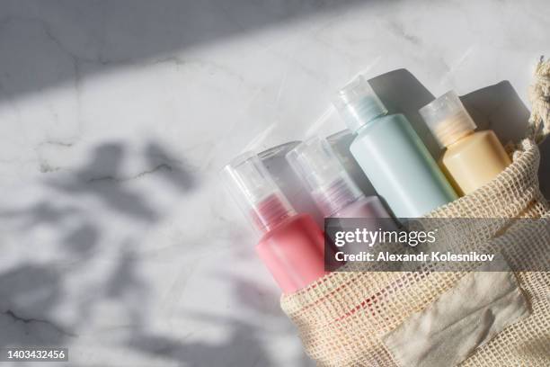 small pastel colors bottles for travelling on white marble background. copy space. flat lay composition of cosmetic products. top view - shampoo stockfoto's en -beelden