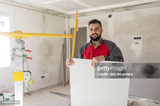 der bauarbeiter installiert gipskartondecken und isolierungen. trockenbaudecke - lift roof stock-fotos und bilder