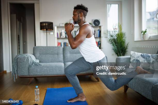 strong athletic fit man exercising at his home - bodyweight training stock pictures, royalty-free photos & images