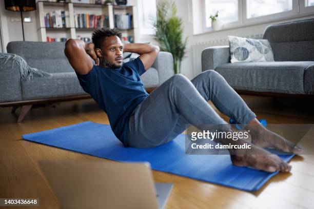 man exercising at home - at home workout stock pictures, royalty-free photos & images