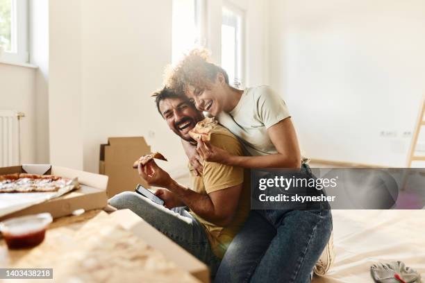 cheerful couple in love eating pizza on a break from home renovation process. - embracing change stock pictures, royalty-free photos & images