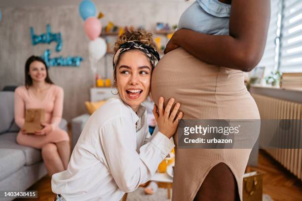 mujer joven que tiene un baby shower en casa - baby shower fotografías e imágenes de stock