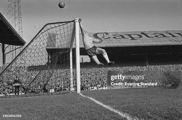 British footballer Gordon Banks , England goalkeeper, punches the ball clear of the cross bar as he makes a save during the 1963–64 British Home...