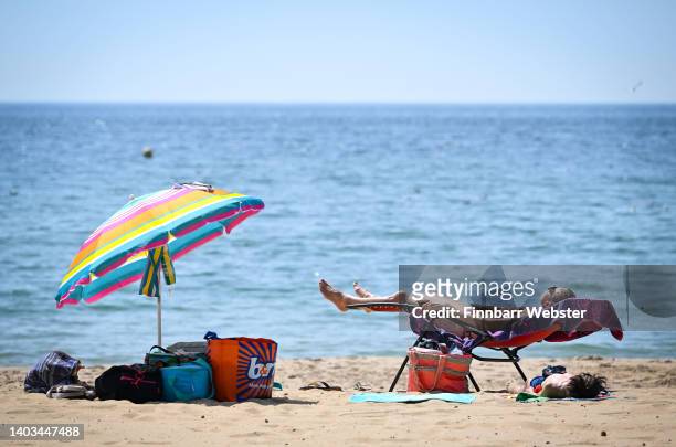 Woman sunbathes on the beach, on June 17, 2022 in Bournemouth, England. Hot air originating in North Africa and travelling up through Spain brings...