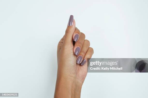 black woman manicured hand with purple nail polish on white background - african american nails stock pictures, royalty-free photos & images