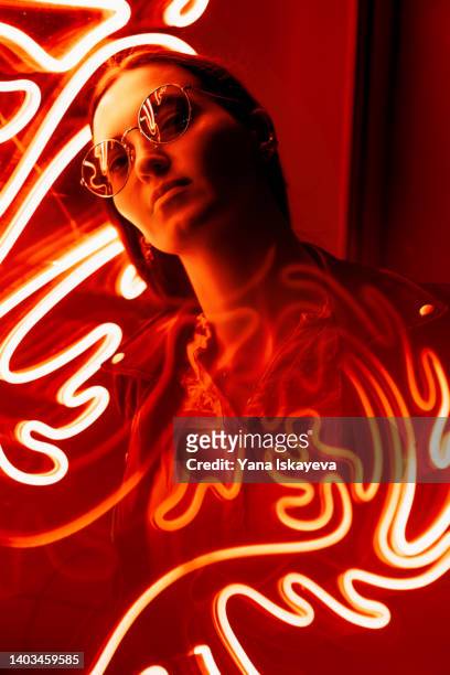 portrait of a woman in glasses against red neon sign - anti disco ストックフォトと画像