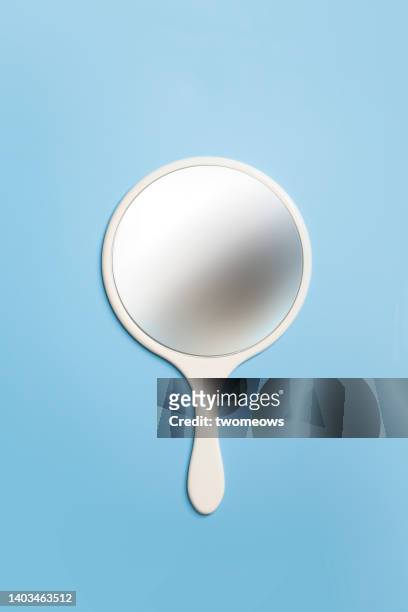 handheld mirror on blue background. - mirror imagens e fotografias de stock