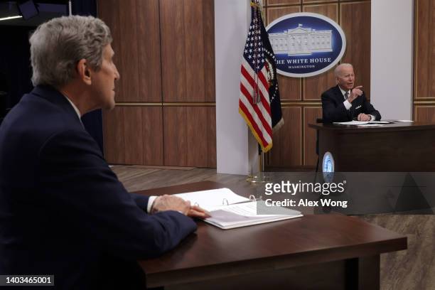 President Joe Biden speaks as Special Presidential Envoy for Climate John Kerry looks on during a virtual Major Economies Forum on Energy and Climate...