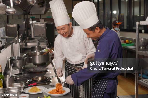 cheerful chefs preparing food in commercial kitchen ,thailand. - baker smelling bread photos et images de collection