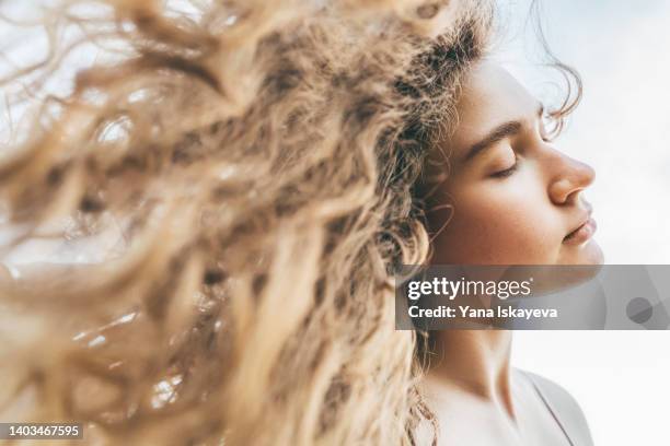 beautiful woman with long curly hair is enjoying warm summer days - femme shampoing photos et images de collection