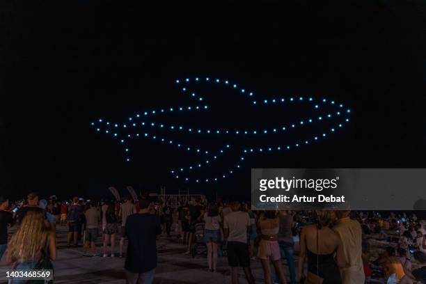 drone show iluminating the sky of barcelona city with a whale shape. - world it show stock-fotos und bilder