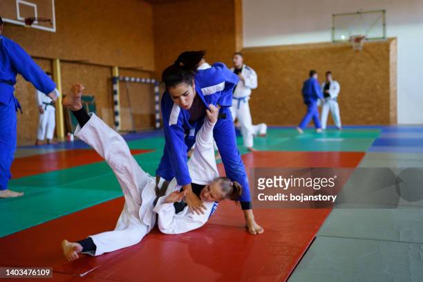 kampfsport-kämpfer trainieren gemeinsam - women's judo stock-fotos und bilder