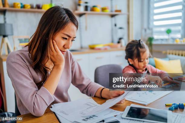 gestresste mutter, die ihre finanzen durchsucht - family budget stock-fotos und bilder