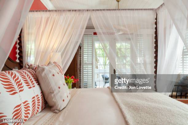 close up view of home interior bedroom with four-poster canopy bed and view towards balcony - luxe hiver stock-fotos und bilder