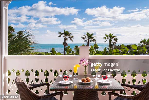 balcony overlooking ocean with breakfast and mimossas in tropical location - luxe hiver stock-fotos und bilder