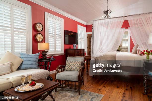 home interior bedroom suite with four-postercanopy  bed and television with red paint - luxe hiver stock-fotos und bilder