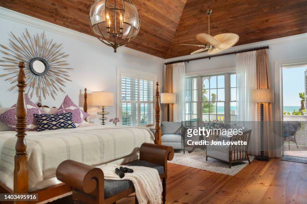 home interior bedroom suite with view towards ocean with rugs, lamps and wood floor - luxe hiver stock-fotos und bilder