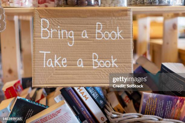 bringen sie ein buch mit nehmen sie ein buchschild - exchanging stock-fotos und bilder