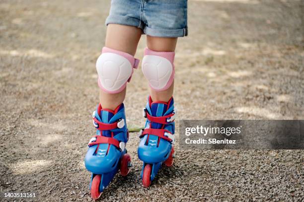 feet of skater girl in blue closed frame in the park - kniebeschermer stockfoto's en -beelden