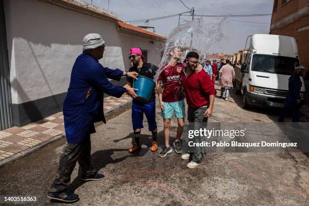 Member of the Pecados 'Sinners' throws water at another members amid a man during a procession on the Day of the Gallows along Camunas' Corpus...