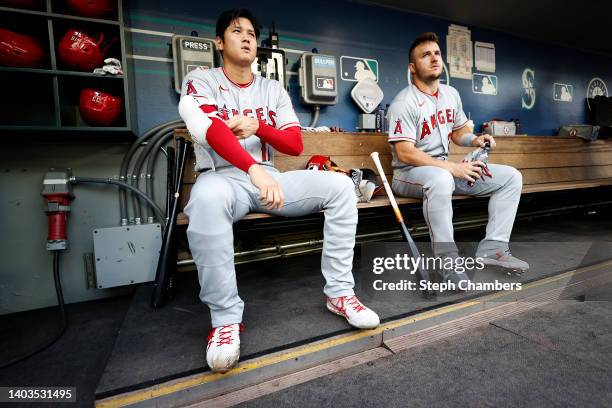 Shohei Ohtani and Mike Trout of the Los Angeles Angels look on before the game against the Seattle Mariners at T-Mobile Park on June 16, 2022 in...