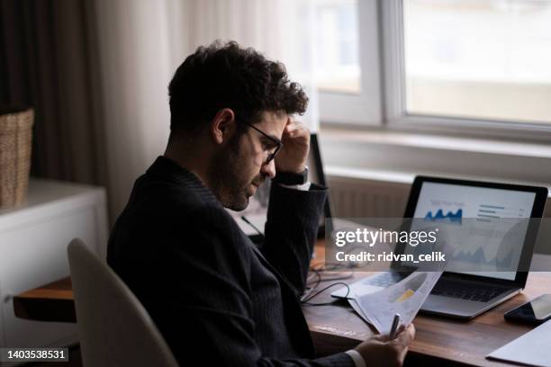 serio pensativo reflexivo joven hombre de negocios - hoja de cálculo fotografías e imágenes de stock