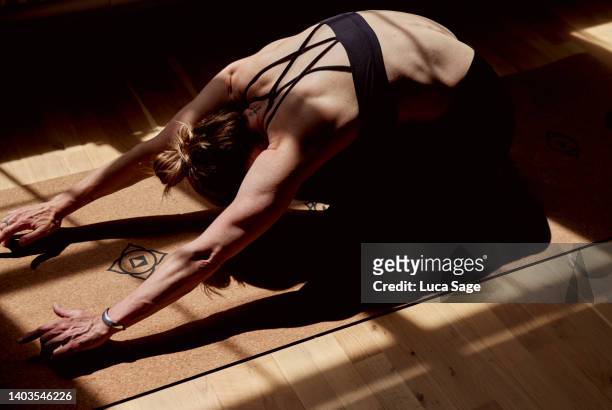 woman practising yoga in a sunny studio - yoga studio - fotografias e filmes do acervo