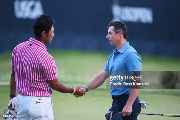Hideki Matsuyama of Japan shakes hands with Rory McIlroy of Northern Ireland after finishing on the 18th green during the second round of the 122nd...