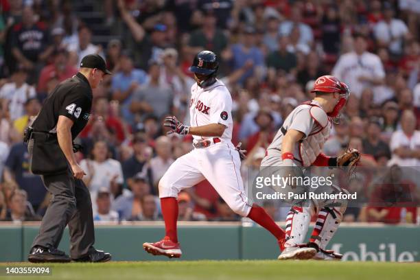 Xander Bogaerts of the Boston Red Sox avoids a tag by Andrew Knizner of the St. Louis Cardinals during the fourth inning at Fenway Park on June 17,...