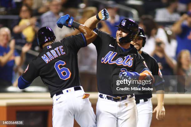 Pete Alonso of the New York Mets celebrates with Starling Marte after hitting a grand slam home run in the sixth inning against the Miami Marlins at...