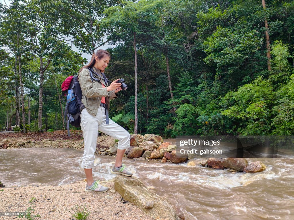 Adult photographer standing in jungl