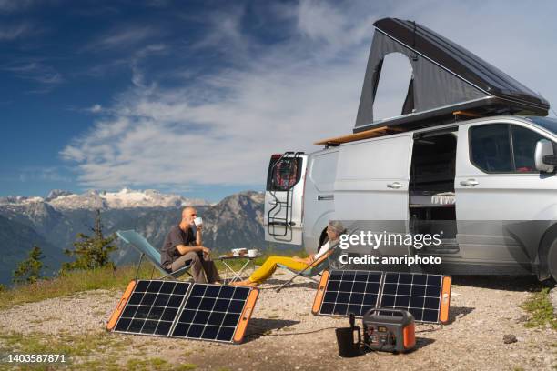 pareja madura autosuficiente en vacaciones de camping en las montañas disfrutando del desayuno - autoconsumo electrico fotografías e imágenes de stock
