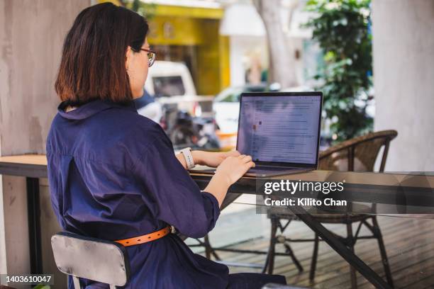 asian woman using laptop outdoor in a cafe - laptop back stock pictures, royalty-free photos & images