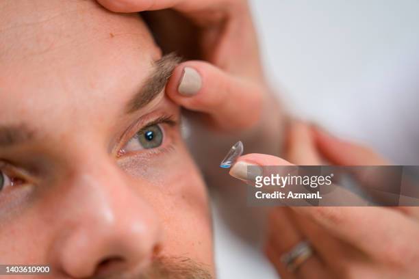 right eye close up of contact lenses reaching the eye - lente de contacto imagens e fotografias de stock